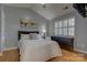 Comfortable bedroom featuring hardwood floors, window with shutters, and decoratively appointed bed at 12928 Sickles Dr, Charlotte, NC 28273