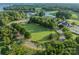 An aerial view shows the community green space encircled by mature trees and winding roads at 142 Tuscany Trl, Mooresville, NC 28117