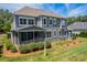 Expansive backyard featuring a screened porch, lush lawn, and mature landscaping, great for entertaining at 142 Tuscany Trl, Mooresville, NC 28117