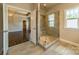 Modern bathroom with a glass-enclosed shower, ceramic tile, and natural light at 142 Tuscany Trl, Mooresville, NC 28117