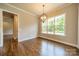 Bright dining room with hardwood floors, modern chandelier, and a large window overlooking the backyard at 142 Tuscany Trl, Mooresville, NC 28117