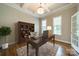 Staged home office features a desk, bookshelf, chair, rug and plenty of natural light at 142 Tuscany Trl, Mooresville, NC 28117