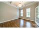 Well-lit home office featuring hardwood floors, elegant ceiling trim, and natural light from two large windows at 142 Tuscany Trl, Mooresville, NC 28117