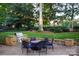 Brick patio with stone accents, a built-in grill, a round table and six chairs at 17048 Jetton Rd, Cornelius, NC 28031