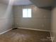 Finished basement area with carpet, paint, and paneling, providing extra living space and a window at 1707 Van Dyke Dr, Charlotte, NC 28213