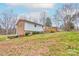 Grassy backyard with two-story house featuring a deck for entertaining and enjoying outdoor activities at 1925 S Lafayette St, Shelby, NC 28152