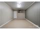 Open basement space with neutral flooring, walls, and built-in shelving with decor at 1925 S Lafayette St, Shelby, NC 28152