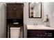 Bathroom featuring a modern vanity, toilet, storage cabinet, and a decorative mirror at 1925 S Lafayette St, Shelby, NC 28152