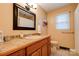 Bathroom with a tile countertop, dark framed mirror, and a window providing natural light at 1925 S Lafayette St, Shelby, NC 28152