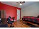 Bedroom featuring red accent wall, wood-look flooring, and a modern gaming setup at 1925 S Lafayette St, Shelby, NC 28152