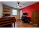 Cozy bedroom with a wooden bed frame, wood-look flooring, and a red accent wall at 1925 S Lafayette St, Shelby, NC 28152