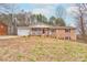 Charming brick home with a covered front porch, attached garage, and mature trees in a spacious yard at 1925 S Lafayette St, Shelby, NC 28152