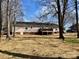 A view of the back exterior of the house with a spacious backyard, complete with mature trees that enhance privacy at 1937 Hickory Dr, Lancaster, SC 29720