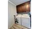 Functional laundry room with washer, dryer, and overhead wood cabinetry at 1937 Hickory Dr, Lancaster, SC 29720