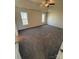 Spacious bedroom with gray carpet, ceiling fan, and two windows for natural light at 1941 Olsen Ln, Charlotte, NC 28213