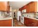 Galley kitchen features wood cabinets, neutral countertops and backsplash, and white appliances at 2003 Hemby Commons Pkwy, Indian Trail, NC 28079