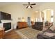 Cozy living room with a fireplace, wood floors, ceiling fan, comfortable seating, and seamless flow to other rooms at 2003 Hemby Commons Pkwy, Indian Trail, NC 28079