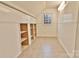 An attic with paneling and built-in shelving, illuminated by a window at 2025 Sojourn Rd, Marshville, NC 28103