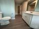 Bathroom featuring sink vanity with marble countertops and toilet with dark wood look floors at 2025 Sojourn Rd, Marshville, NC 28103