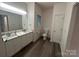 Bright bathroom featuring double sink vanity with marble countertops and toilet with dark wood look floors at 2025 Sojourn Rd, Marshville, NC 28103