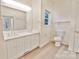 Bright bathroom featuring a double sink vanity, toilet, and neutral wall color at 2025 Sojourn Rd, Marshville, NC 28103