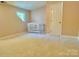 Neutral bedroom with a window bringing in natural light and a baby crib in the corner at 2025 Sojourn Rd, Marshville, NC 28103