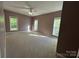 Spacious bedroom with carpeted floors, ceiling fan, and three windows with natural light at 2025 Sojourn Rd, Marshville, NC 28103