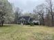 A lovely home featuring gray siding, a black roof, and surrounded by trees, offering privacy and curb appeal at 2025 Sojourn Rd, Marshville, NC 28103