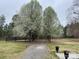 Landscaped grounds with blossoming trees and a long driveway at 2025 Sojourn Rd, Marshville, NC 28103