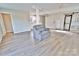 Living room with light grey armchair, flooring, and access to kitchen at 2025 Sojourn Rd, Marshville, NC 28103