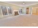 Spacious living room with a fireplace, large windows, and neutral carpeting at 2025 Sojourn Rd, Marshville, NC 28103