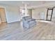 Spacious living room featuring modern floors, a gray chair, and a view into the kitchen at 2025 Sojourn Rd, Marshville, NC 28103