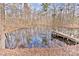Scenic pond view with a wooden dock surrounded by peaceful woods at 2025 Sojourn Rd, Marshville, NC 28103