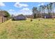 Spacious backyard with a wood fence, metal shed, green grass, and single-story home at 2211 Waverly St, Albemarle, NC 28001