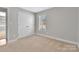 Well-lit bedroom with neutral carpet, large window, and double-door closet space at 2211 Waverly St, Albemarle, NC 28001