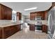 Bright kitchen with stainless steel appliances, wood cabinets, marble countertops, and wood-look flooring at 2211 Waverly St, Albemarle, NC 28001