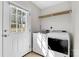 A laundry room with white washer and dryer next to a bright white door at 2211 Waverly St, Albemarle, NC 28001