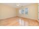 Bedroom featuring wood floors and three large windows offering ample natural light at 2320 Christensens Ct, Charlotte, NC 28270