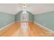 Expansive bonus room with hardwood flooring, neutral paint, and arched window at 2320 Christensens Ct, Charlotte, NC 28270