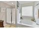 Bright bathroom featuring a soaking tub under a window and a separate shower with a glass door at 2437 Grinstead Ct, Clover, SC 29710