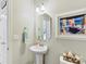 Charming powder room featuring a pedestal sink, decorative mirror, and a seaside-themed painting at 2437 Grinstead Ct, Clover, SC 29710