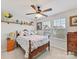 Cozy bedroom with floral bedding, decorative shelf, natural light, and wooden furniture at 2437 Grinstead Ct, Clover, SC 29710