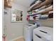 Functional laundry room features modern white washer and dryer with neatly organized shelving above at 2437 Grinstead Ct, Clover, SC 29710