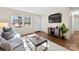 Bright living room with hardwood floors, a large window, and a modern entertainment center at 2500 Danforth Ln, Charlotte, NC 28208