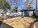 A gravel backyard with a fire pit, landscaping, and a white fence for added privacy at 2919 Park Rd, Charlotte, NC 28209