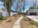 Landscaped backyard with a stone pathway leading to a garage and shed in a fully fenced yard at 2919 Park Rd, Charlotte, NC 28209