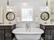 Charming bathroom featuring dual sinks, freestanding tub, and stylish round mirrors at 2919 Park Rd, Charlotte, NC 28209