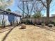 Gravel backyard with fire pit and landscaping, bordered by a wooden fence and mature trees at 2919 Park Rd, Charlotte, NC 28209