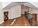 Hallway featuring hardwood floors, railing, and rustic wood accent door under the eaves at 2919 Park Rd, Charlotte, NC 28209