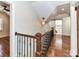 Hallway with wooden floors and wrought iron railing leads to bathroom with barn door at 2919 Park Rd, Charlotte, NC 28209